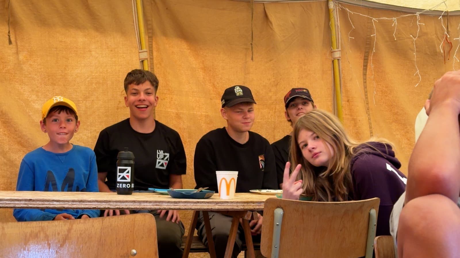 Een groep deelnemers zit samen aan tafel in de grote tent